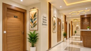 Een hotelgangen met houten deuren, een receptiebalie en kunstwerken in lijsten aan de muren.