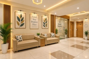 A hotel lobby with a reception desk, two sofas, framed artwork, and a sign for Hotel Square. - Hotel Royal Square, Ahmedabad (Ahmedabad)