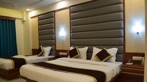 A hotel room with two beds, each with a headboard, bedside tables, and a telephone. - Hotel Royal Square, Ahmedabad (Ahmedabad)
