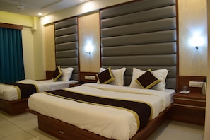 A hotel room with two beds, each with a headboard, bedside tables, and a telephone. - Hotel Royal Square, Ahmedabad (Ahmedabad)