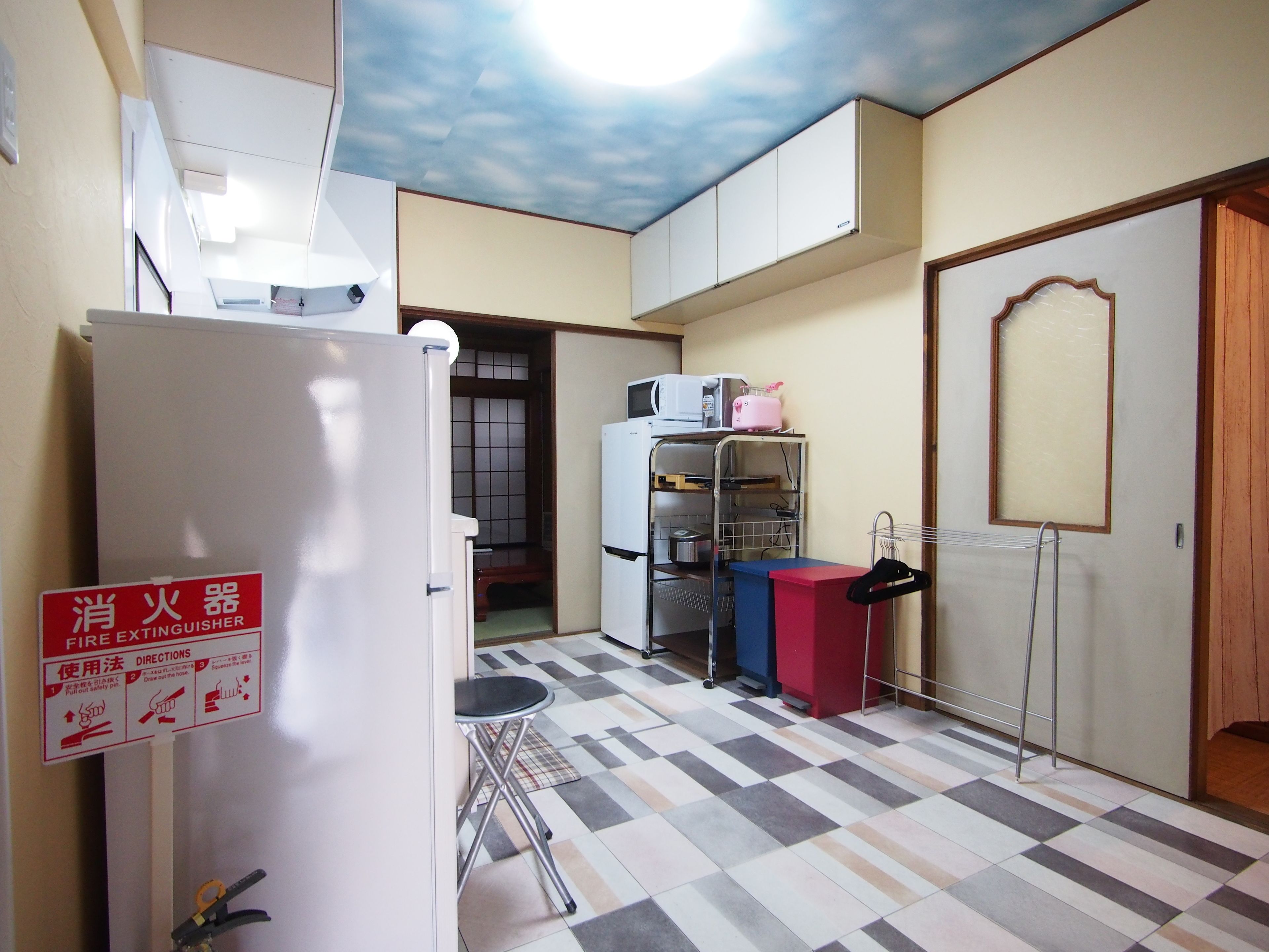 A compact kitchen with a refrigerator, microwave, and a small dining area.