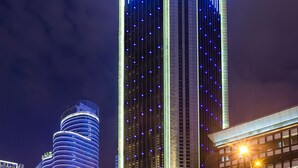 A high-rise building with vertical lighting accents and a prominent sign at the top. - Chongqing YiMei Hotel (Chongqing)