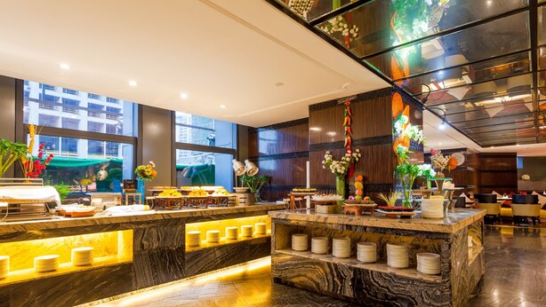 A modern hotel lobby with marble counters, a large aquarium, and a view of the cityscape. - Chongqing YiMei Hotel (Chongqing)