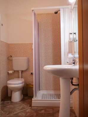 Un baño con inodoro, ducha y lavamanos.