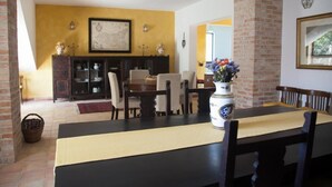Een eethoek met een tafel gedekt voor twee personen, een open haard en een kaart aan de muur.