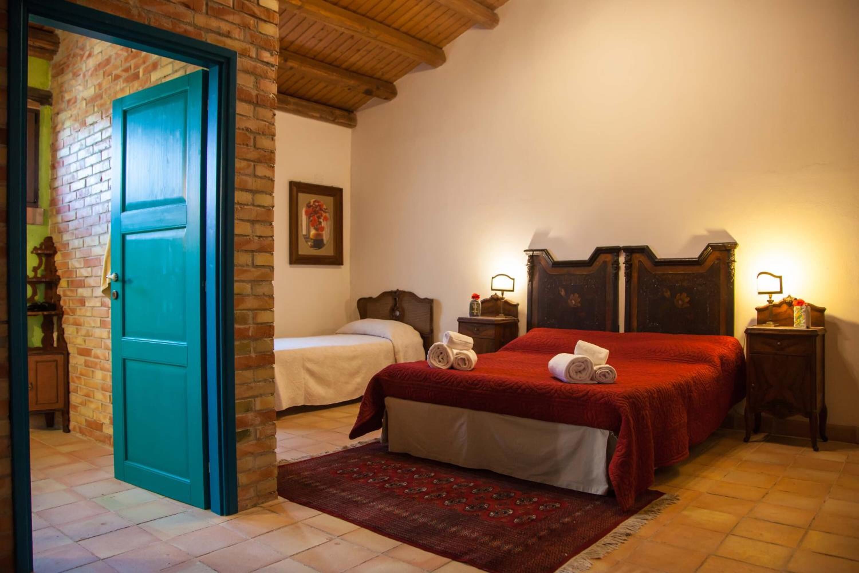 A room with two beds, a red carpet, and a wooden ceiling.
