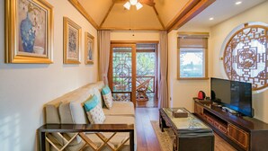 A living room with a sofa, television, and ceiling fan. - Li Jiang Tang Feng Yard No.4 (Lijiang)