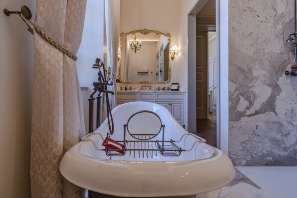 A bathroom with a white sink, a mirror with an ornate frame, and a chandelier.