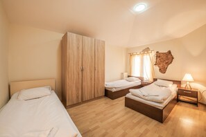 A bedroom with two single beds, a wardrobe, a nightstand with a lamp, and a wall-mounted decoration. - Vitosha Flat (Sofia)