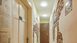 A hallway with a wooden floor, a brick wall, and a door labeled "Guest Apartment". - Vitosha Flat (Sofia)
