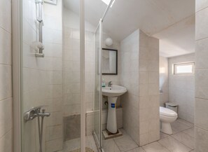A bathroom with a glass-enclosed shower, a sink, and a toilet. - Vitosha Flat (Sofia)