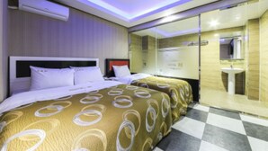 Een moderne hotelkamer met een groot bed, een aparte badkamer en een geruit vloertje.