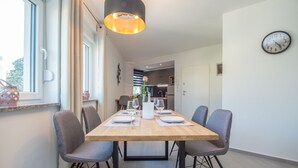Een moderne eethoek met een houten tafel voor vier personen, omringd door grijze stoelen.