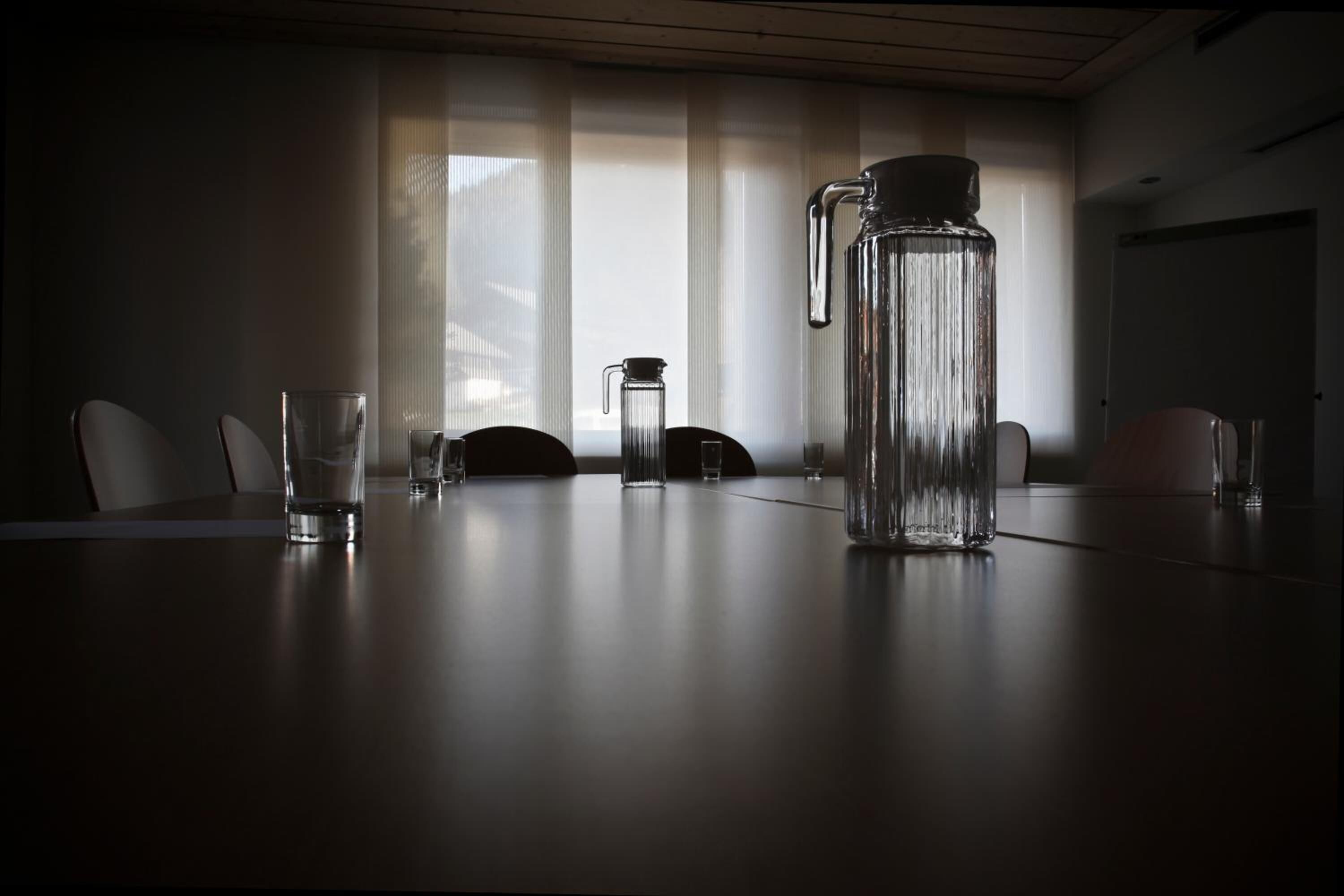 A conference room with a large table, chairs, and a water dispenser.