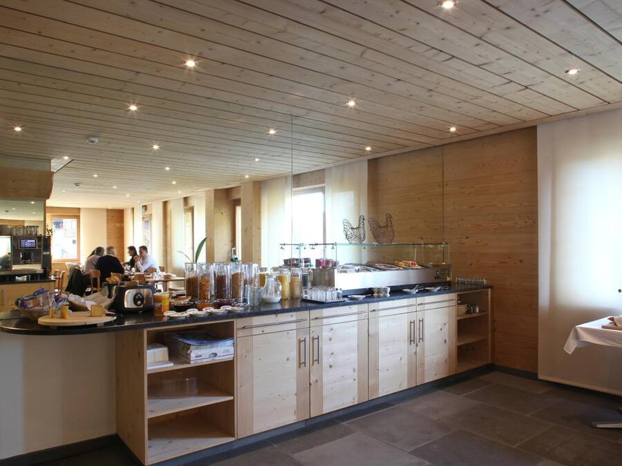 Una cocina moderna con armarios de madera, una isla central con alimentos y una cafetera a la vista.