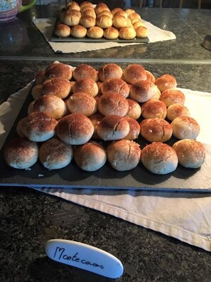 A tray of freshly baked bread rolls on a kitchen counter. - Helvetia Hôtel Résidence (Troistorrents)