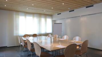 A conference room with a long table, chairs, and a whiteboard.
