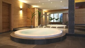 A spa area with a circular hot tub, wooden walls, and a stone floor.