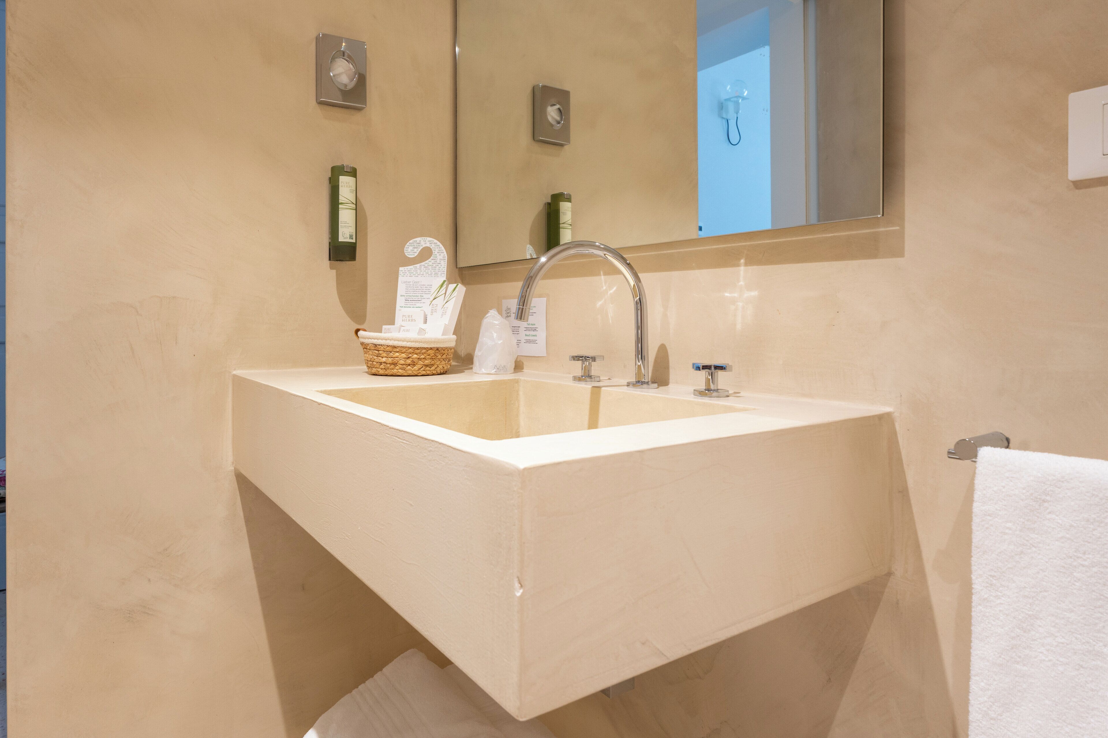 A bathroom with a large sink, a mirror, and a towel rack.