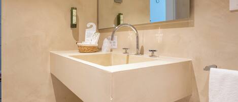 A bathroom with a large sink, a mirror, and a towel rack.