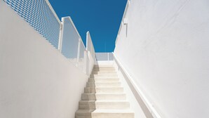 A staircase leading upwards with white walls and a blue sky in the background. - Donna Domenica Boutique Suites (Polignano a Mare)