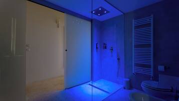 A modern bathroom with a glass shower enclosure, a toilet, and a sink.