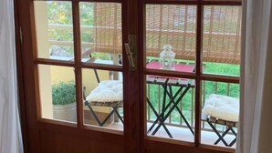 A wooden-framed door with a view of a patio area. - Catarina (Tollo)