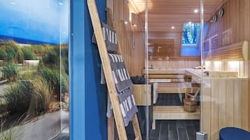 Uma sala de sauna com bancos de madeira, divisória de vidro e vista para o exterior.