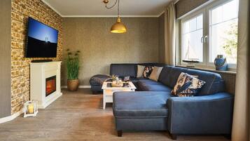 Een flatscreentelevisie, een open haard en vloerverwarming