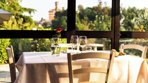 Mesa de comedor al aire libre con vistas a zonas verdes y edificios al fondo.