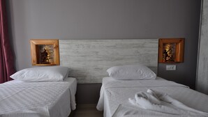 A hotel room with two beds, white linens, and a wooden headboard. - Queen Bee Hotel (Selçuk)