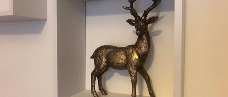 A framed deer sculpture on a wall.