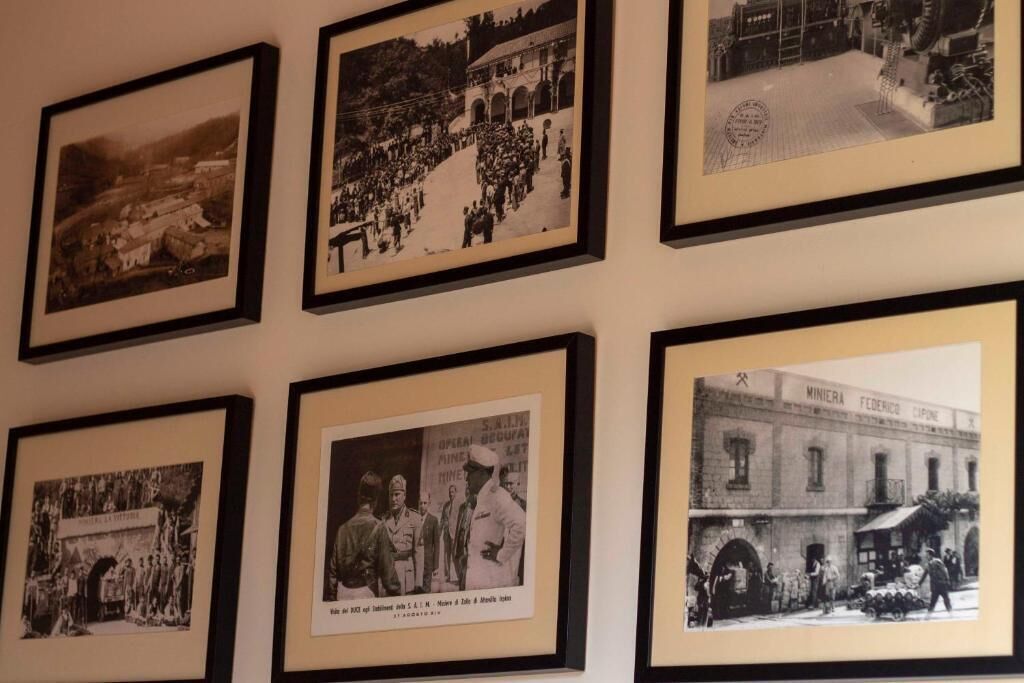 Un mur orné de six photographies en noir et blanc, encadrées.
