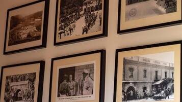 Un mur orné de six photographies en noir et blanc, encadrées.