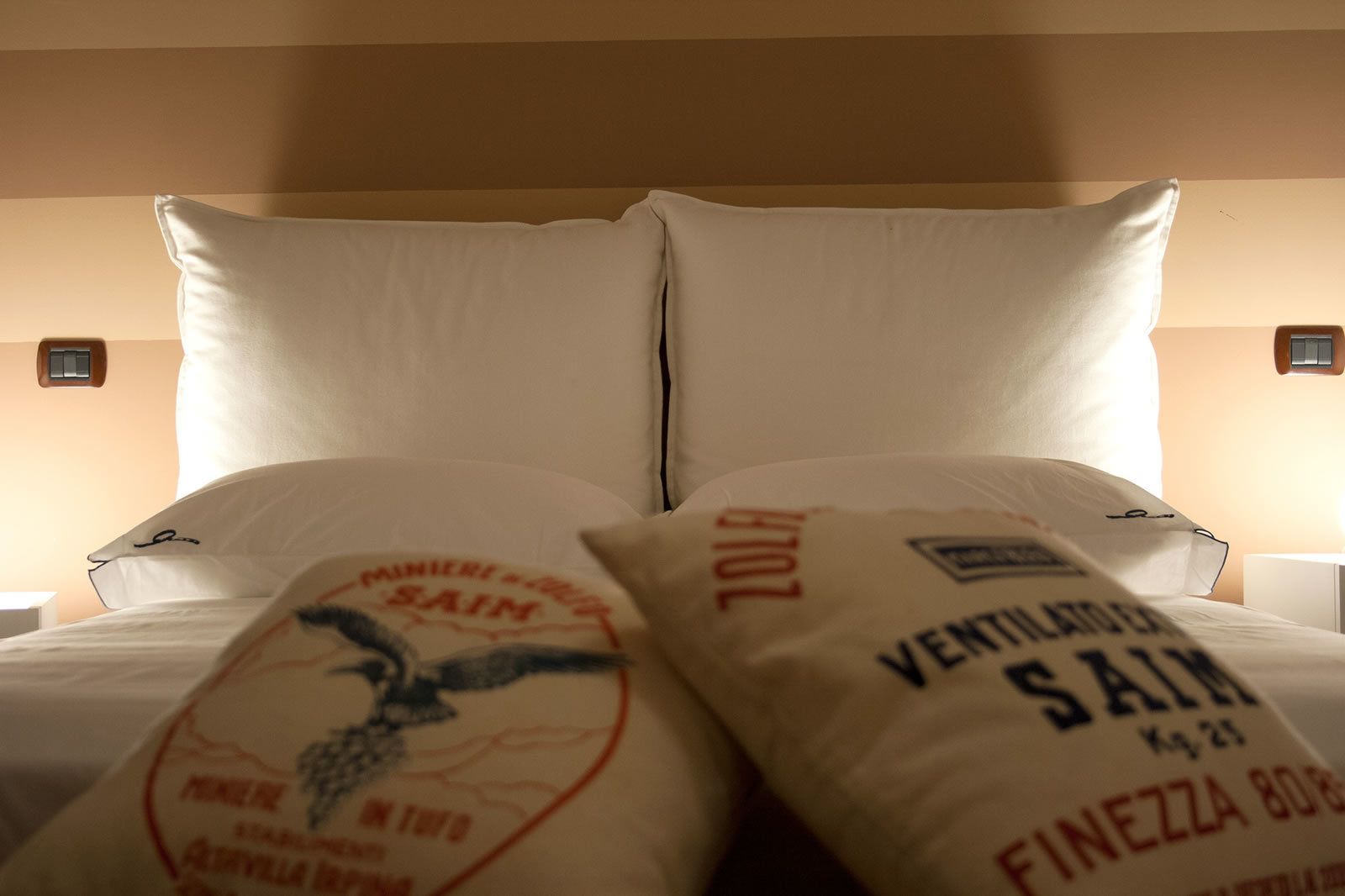 Una cama con dos almohadas, cada una con un logotipo y texto.
