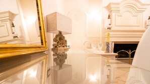 A luxurious room with a reflective marble floor, a classic chandelier, and a fireplace. - Boutique - Lodge & Suites (Crotone)