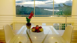 A dining area with a table, chairs, a potted plant, and a fruit bowl. - Ho Gia Trang (Tan Ha Lam Ha)