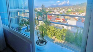 Un balcón con una planta en maceta y vistas a la ciudad.