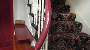 A staircase with a red handrail, carpeted steps, and a sign indicating a guest house. - Jasmine Central Guest House (Aberdeen)