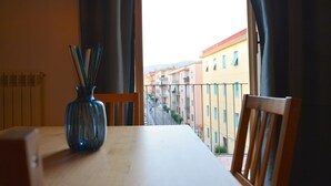 A balcony with a view of a street and buildings, a wooden table, and a vase with pencils. - Dimora Paternò (Caserta)