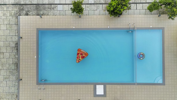 A rectangular pool with a ladder on one side, surrounded by a tiled walkway. - The Sanihara Hotel & Resort (Vythiri)