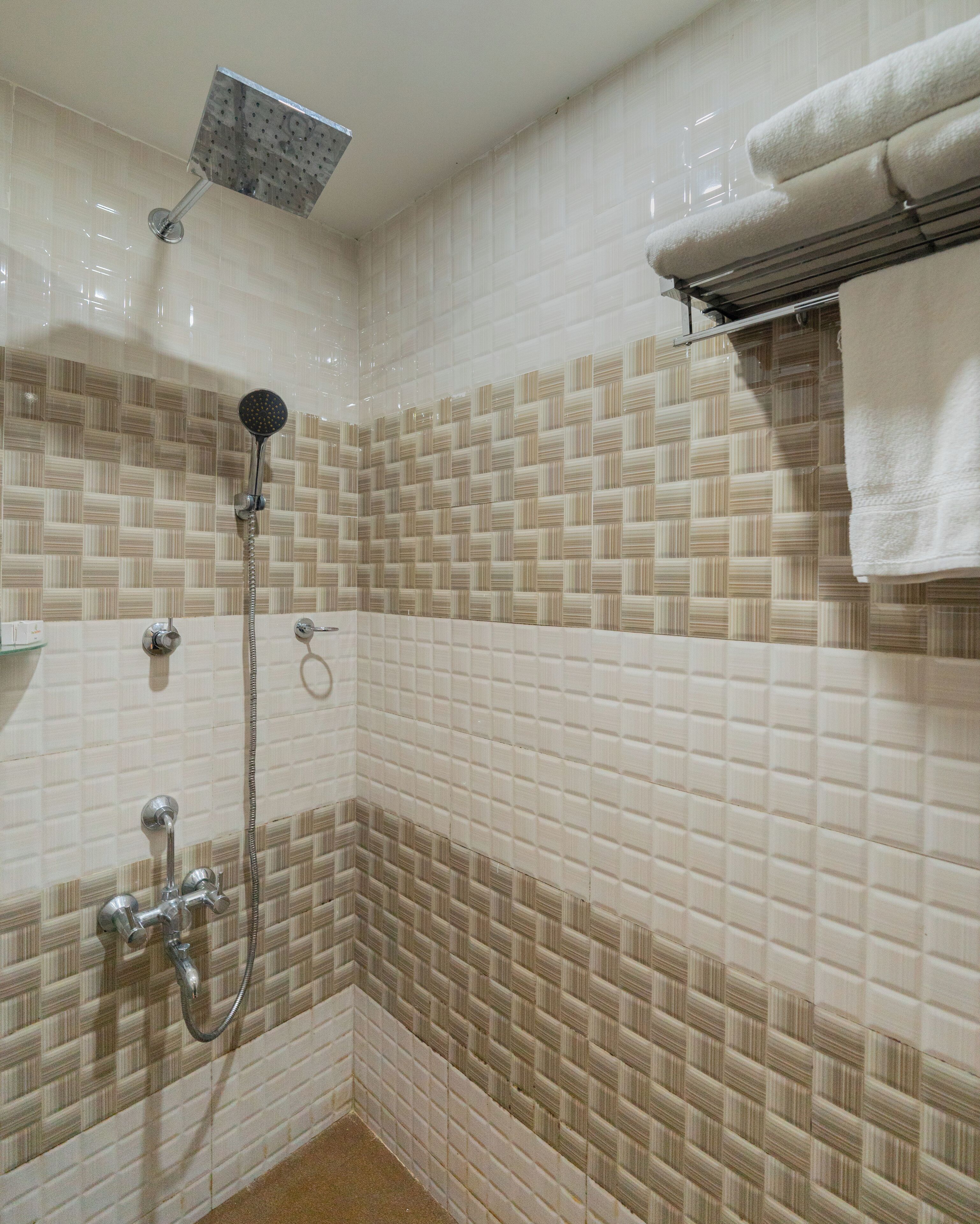 A bathroom with a shower, a towel rack, and a sink.
