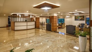 A spacious lobby with a reception desk, seating area, and a large potted plant. - The Sanihara Hotel & Resort (Vythiri)