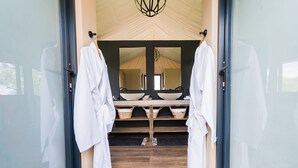 Une salle de bain moderne avec un grand miroir, un plancher en bois et un lavabo doté d’une grande cuve.