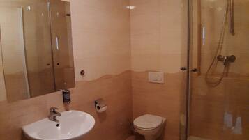 A bathroom with a sink, toilet, and glass-enclosed shower.
