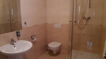 Ein Badezimmer mit Waschbecken, Toilette und einer Duschkabine.
