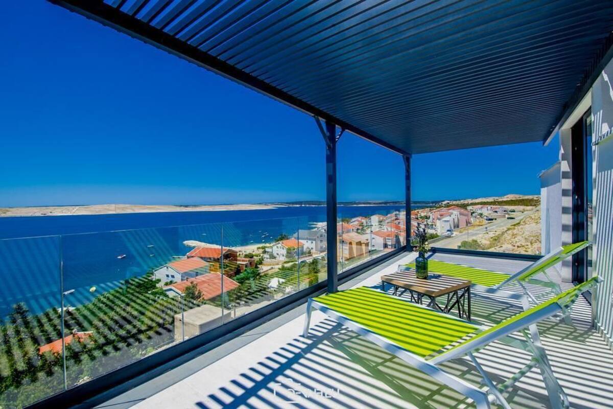 A balcony with a view of the sea and a town.