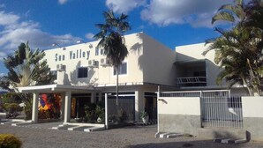 A building with the sign "Sun Valley" and a gated entrance. - Hotel Sun Valley (Senhor Do Bonfim)