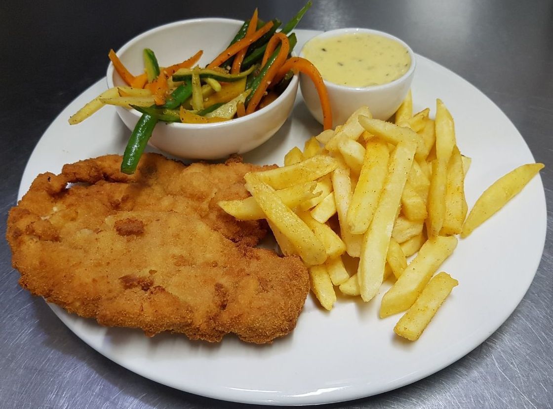 Ein Teller mit einem panierten Fischstäbchen, Pommes Frites und zwei Beilagen.