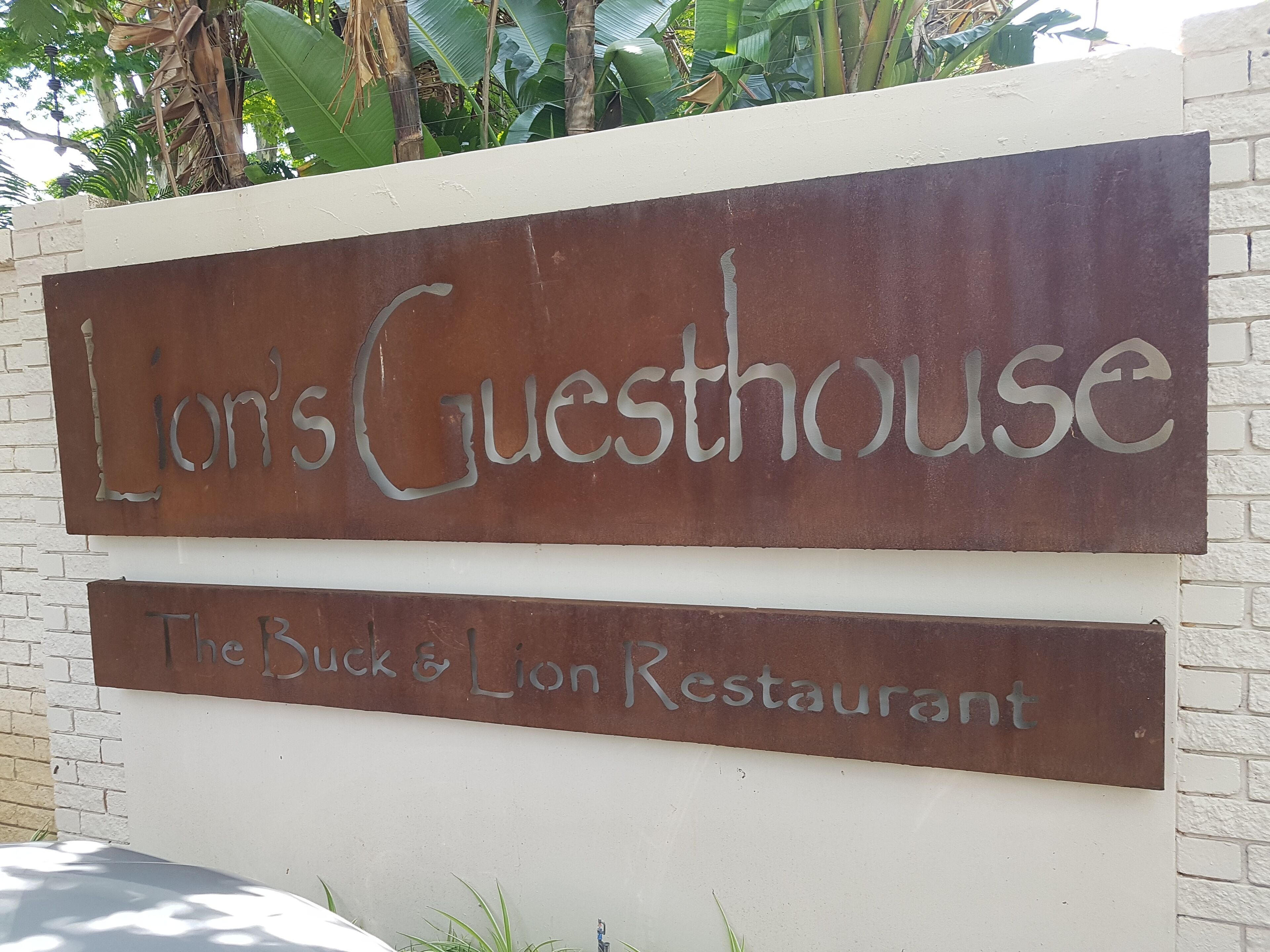 Letrero que indica 'Lion's Guesthouse' y 'The Buck & Lion Restaurant'.